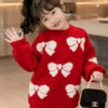 Close-up of white 3D bow jacquard pattern on red knit sweater, kids clothes Kenya