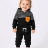Toddler girl walking indoors in a black and white striped tracksuit set from ActiveKids.